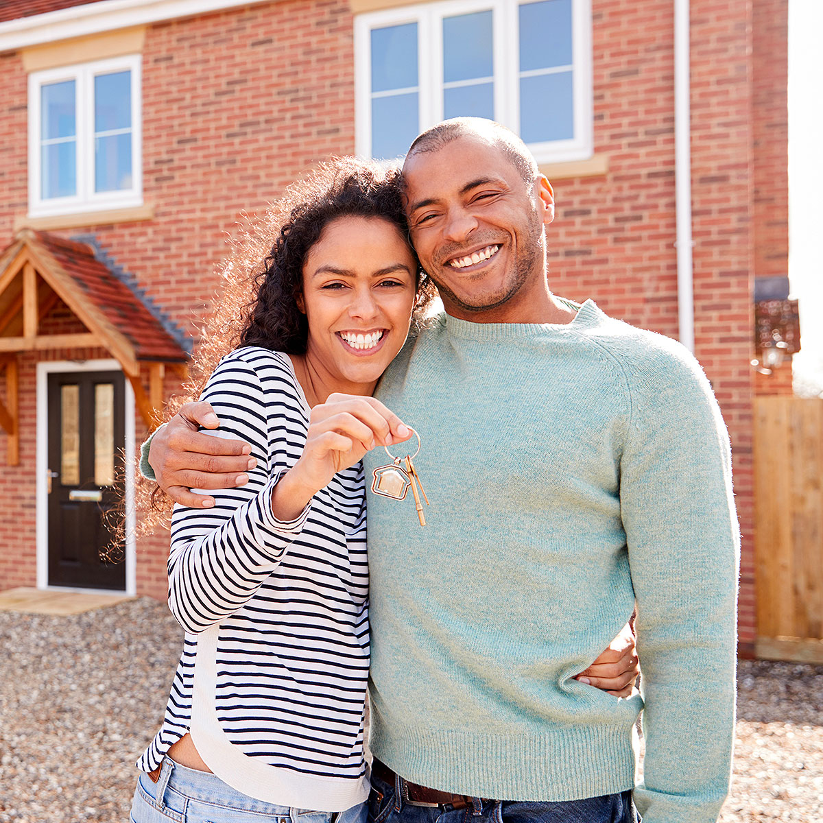 Couple in front of their house holding keys