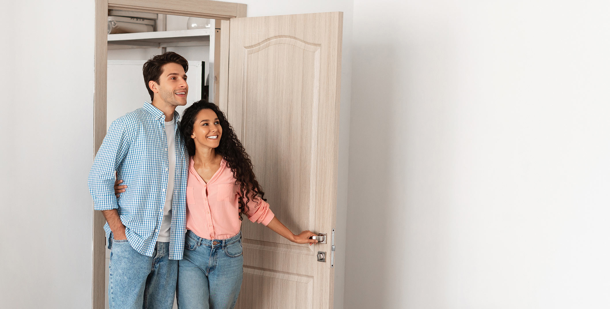 A young couple walking into a bedroom
